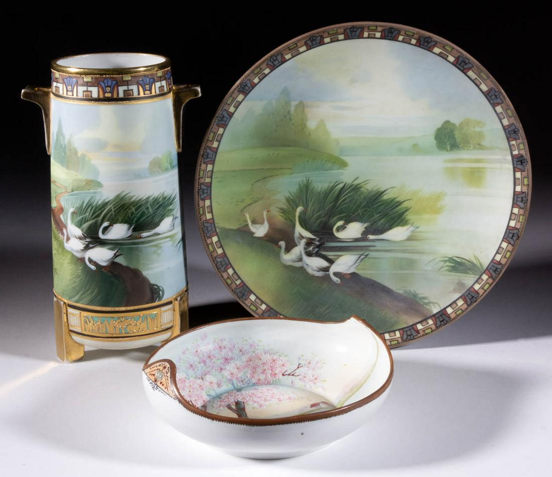 JAPANESE NIPPON HAND-PAINTED PORCELAIN ARTICLES, LOT OF: JAPANESE NIPPON HAND-PAINTED PORCELAIN ARTICLES, LOT OF THREE, each having polychrome scenes with raised decorations, comprising a plaque and a tri-footed cylindrical vase with scene depicting white g