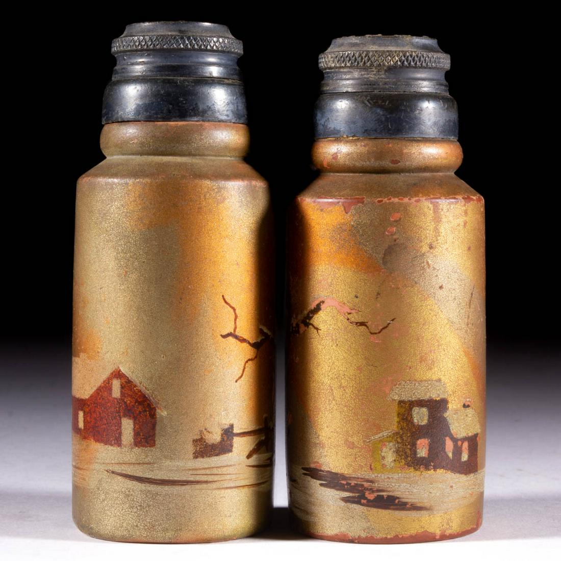 DECORATED REDWARE PAIR OF SALT AND PEPPER SHAKERS: DECORATED REDWARE PAIR OF SALT AND PEPPER SHAKERS, golden iridescent ground with polychrome-enamel decoration, each being cylindrical form with winter cabin scenes, period two-part lids. Maker unverif
