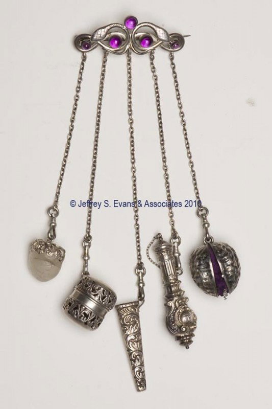THOMAS S. BROGAN STERLING SILVER FIGURAL NEEDLEWORKI: THOMAS S. BROGAN STERLING SILVER FIGURAL NEEDLEWORKING CHATELAINE, brooch pin attached to a plaque with entwining snakes and five amethyst colored stones, suspending five chains and five non-matching 