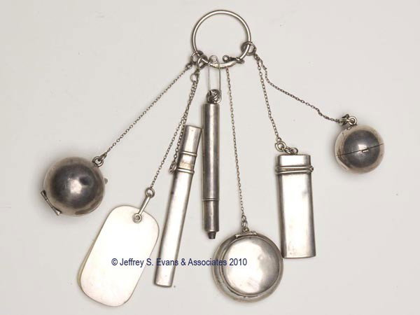 STERLING SILVER FIGURAL FINGER RING CHATELAINE: STERLING SILVER FIGURAL FINGER RING CHATELAINE, ring depicting a snake, suspending six chains together by association, and seven unpatterned appendages. Appendages consist of two coin dispensers, one 