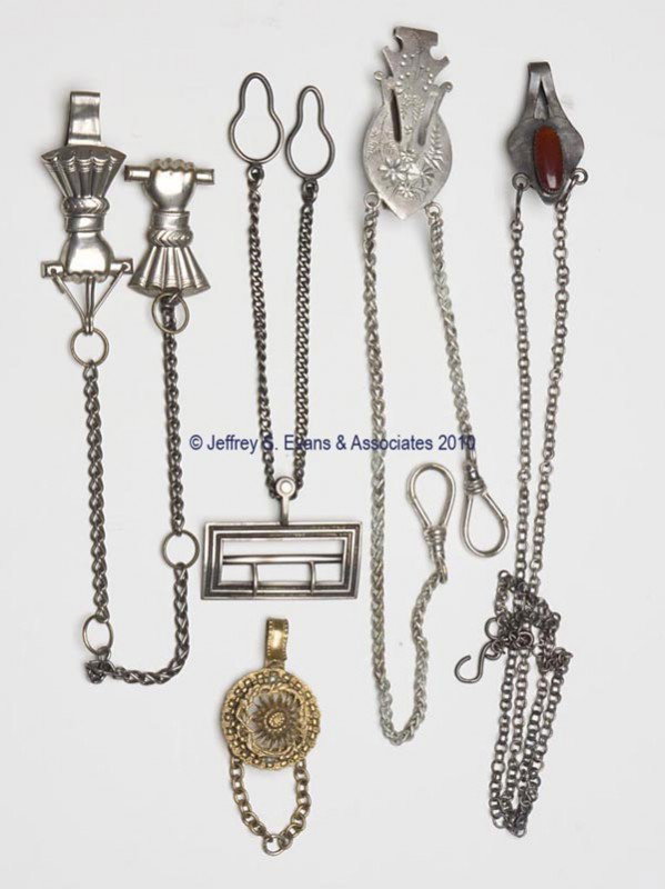 VARIOUS METAL CHATELAINE CLIPS, LOT OF FOUR: VARIOUS METAL CHATELAINE CLIPS, LOT OF FOUR, consisting of a figural arm with single chain suspending a matching figural arm which has two links attached; a rectangular buckle style suspending a singl