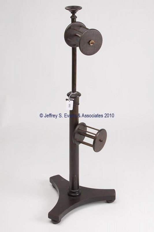 MAHOGANY VERTICAL YARN WINDER: MAHOGANY VERTICAL YARN WINDER, stylized tripod-form base with three bun feet, central turned post supporting two cage winders, underside with paint stamped "3544". Second half 19th century. 39 1/4" h,