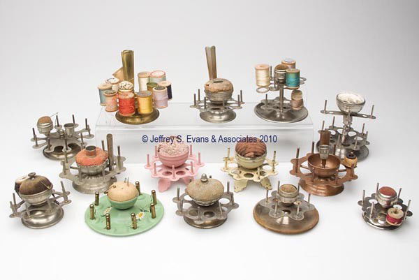 METAL REEL HOLDERS WITH PIN CUSHIONS, LOT OF 14: METAL REEL HOLDERS WITH PIN CUSHIONS, LOT OF 14, consisting of ten revolving examples and four stationary examples, six examples with additional fittings including scissor sheaths and thimble holders,