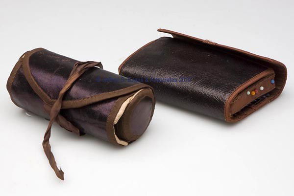 LEATHER ROLL-OUT SEWING WORK CASES, LOT OF TWO: LEATHER ROLL-OUT SEWING WORK CASES, LOT OF TWO, consisting of a cylindrical-form example with pink silk lining and a built-in thimble holder and compartment; and a wallet-form example with brown silk