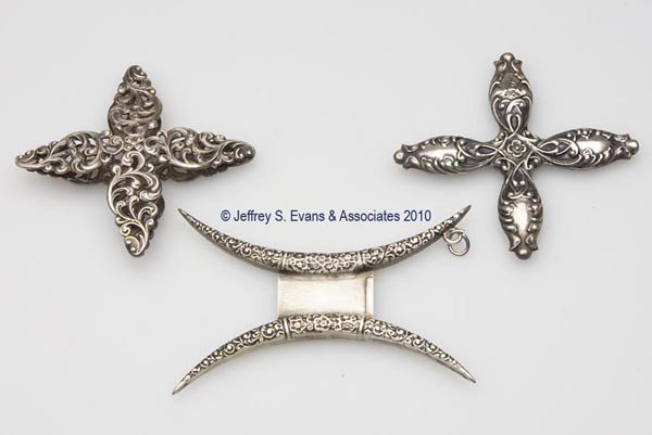 STERLING SILVER SILK WINDERS, LOT OF THREE: STERLING SILVER SILK WINDERS, LOT OF THREE, consisting of two marked Reddall & Co. examples embossed with floral and scroll pattern, one example with a chatelaine link; and an unmarked Unger Bros. exa