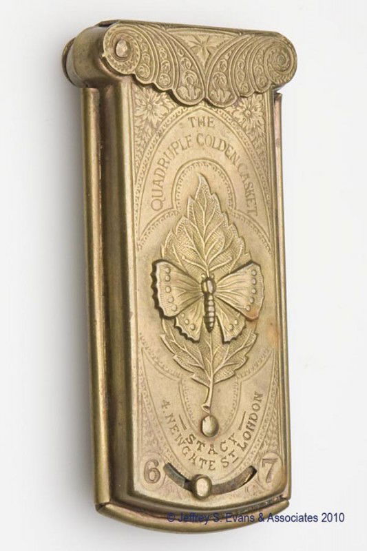 STACY BRASS "THE QUADRUPLE GOLDEN CASKET" NEEDLE C: STACY BRASS "THE QUADRUPLE GOLDEN CASKET" NEEDLE CASE, flip-top lid opens to reveal three compartments for needle packets, each side with a mechanical slide to dispense the compartments, each side emb