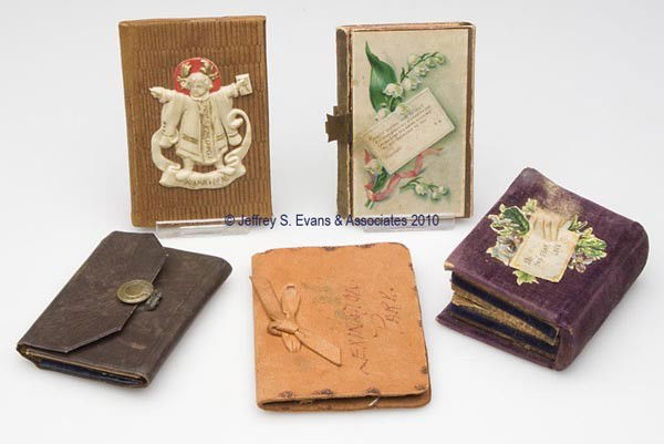 FABRIC AND LEATHER NEEDLE CASES, LOT OF FIVE: FABRIC AND LEATHER NEEDLE CASES, LOT OF FIVE, consisting of three book-form examples, including one with an applied celluloid/plastic child figure over a banner embossed "Munchen" and fitted with an i