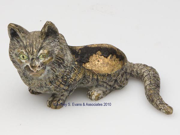 VIENNA BRONZE FIGURAL PIN CUSHION: VIENNA BRONZE FIGURAL PIN CUSHION, depicting a sitting cat, traces of paint decoration, illegible stamp to base. Late 19th/early 20th century. 1 7/8" h overall. Provenance: Collection of the late Hild