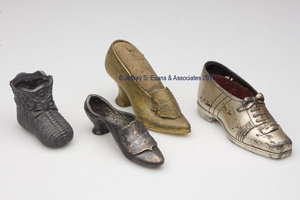 VARIOUS METALS SOUVENIRED AND FIGURAL PIN CUSHIONS: VARIOUS METALS SOUVENIRED AND FIGURAL PIN CUSHIONS, LOT OF FOUR, consisting of a Jennings Brothers silver-plated shoe with "New Orleans, LA", sole embossed "J. B. 1426", original burgundy velvet pin c