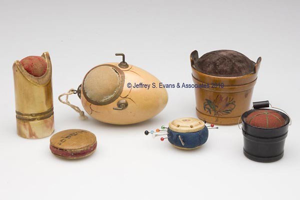 WOODEN FIGURAL PIN CUSHIONS, LOT OF SIX: WOODEN FIGURAL PIN CUSHIONS, LOT OF SIX, consisting of an egg-form example with link and two hooks; a bucket form with bail handle; a barrel form with hand painted floral decoration and verse to rever