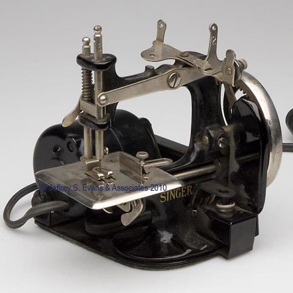 SINGER MANUFACTURING CO. ELECTRIC MODEL 20 IRON TO: SINGER MANUFACTURING CO. ELECTRIC MODEL 20 IRON TOY SEWING MACHINE, original black paint and gilt-stenciled lettering, seven spoke chrome finish fly wheel, impressed with numbers one thru four and six