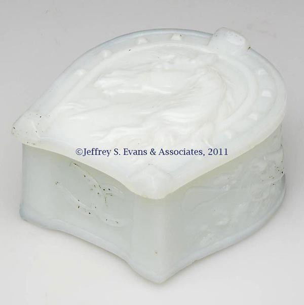 HORSESHOE BOX WITH HORSE HEAD: HORSESHOE BOX WITH HORSE HEAD , opaque white/milk glass, two entwined horseshoes on end, with a whip and bugle on each side. Alton Mfg Co. at the old Boston & Sandwich Glass Co. site. Early 20th centu