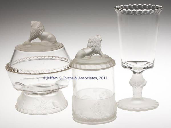 LION - FROSTED TABLE ARTICLES, LOT OF THREE: LION - FROSTED TABLE ARTICLES, LOT OF THREE, colorless and frosted, comprising a butter dish and marmalade/pickle jar, each with crouching lion finial, and a celery vase. Gillinder & Sons. Fourth quar