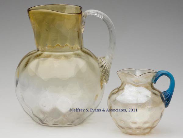 PHOENIX SPOT OPTIC WATER PITCHER: PHOENIX SPOT OPTIC WATER PITCHER, Bronze die-away/amber shading to colorless, round neck with tooled triangular rim, colorless applied reeded handle, polished pontil mark. Together with a light amber 
