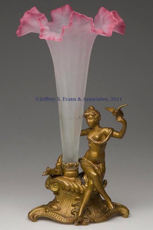 VICTORIAN SINGLE-TRUMPET EPERGNE: VICTORIAN SINGLE-TRUMPET EPERGNE, deep pink shading to colorless, lightly twisted ribs with satin finish, fitted in a gilded spelter stand featuring a seated semi-nude young lady with a bird on her ha