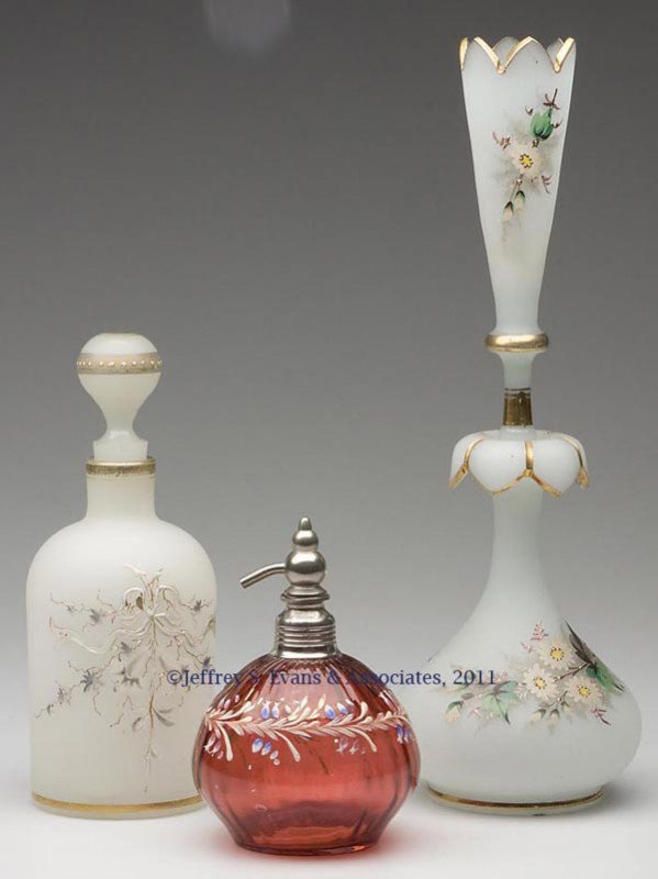 VICTORIAN GLASS COLOGNE BOTTLES, LOT OF THREE: VICTORIAN GLASS COLOGNE BOTTLES, LOT OF THREE, comprising a ribbed cranberry example with polychrome decoration and an ill-fitting atomizer, and two opaline examples, one with vase stopper and rough p
