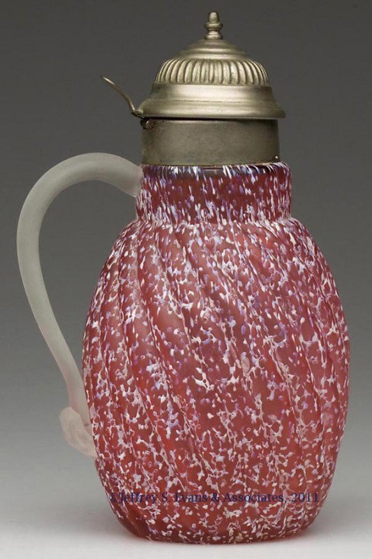 REVERSE SWIRL - GRANITE WARE SYRUP PITCHER: REVERSE SWIRL - GRANITE WARE SYRUP PITCHER, cranberry with opal and blue frit, satin finish, colorless satin-finish applied handle, period lid. Late 19th/early 20th century. 7" HOA. Provenance: From a