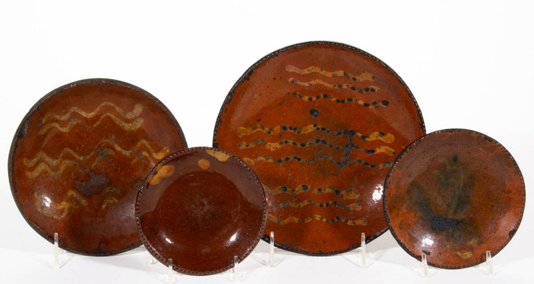 AMERICAN DECORATED EARTHENWARE / REDWARE PLATES, LOT OF: AMERICAN DECORATED EARTHENWARE / REDWARE PLATES, LOT OF FOUR, single lead-glazed, each having coggled rim and yellow-slip trailed decoration, including two having three bands of wavy lines and one fea