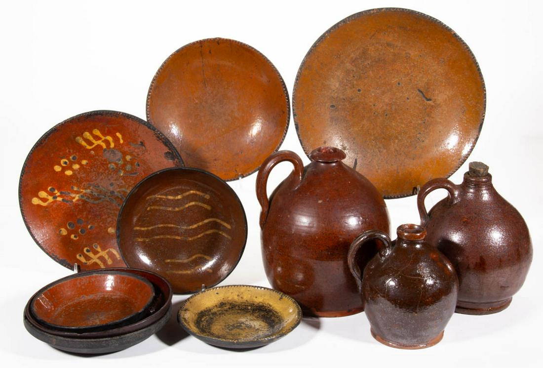 AMERICAN EARTHENWARE / REDWARE ARTICLES, LOT OF 11: AMERICAN EARTHENWARE / REDWARE ARTICLES, LOT OF 11, including three ovoid jugs with strap handles, two yellow-slip decorated plates including one with three bands of double wavy lines and one having c