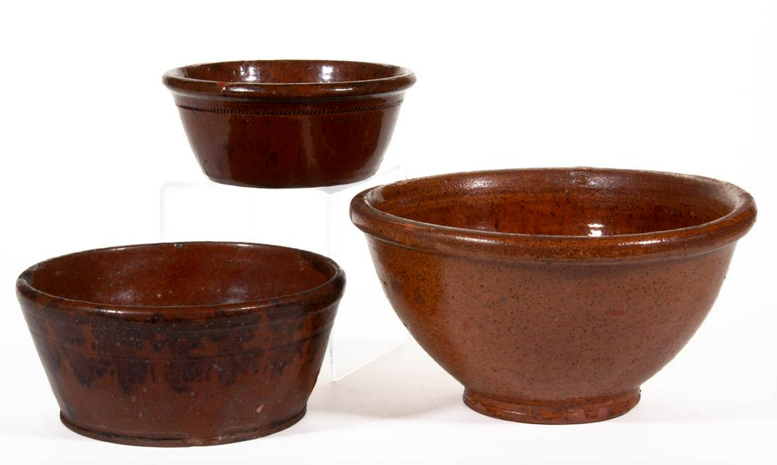AMERICAN EARTHENWARE / REDWARE BOWLS / PANS, LOT OF: AMERICAN EARTHENWARE / REDWARE BOWLS / PANS, LOT OF THREE, lead-glazed, each having rounded rim, including one with manganese splotches, one having coggled ring/band decoration below rim, and one deep