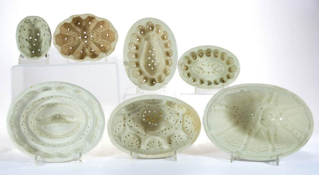 ASSORTED IRONSTONE CHEESE / FOOD MOLDS, LOT OF SEVEN: ASSORTED IRONSTONE CHEESE / FOOD MOLDS, LOT OF SEVEN, each of ovoid form with multiple pierced holes, interior designs include a fish, a seashell, a stemmed rose, a pineapple, and a stemmed tulip flow