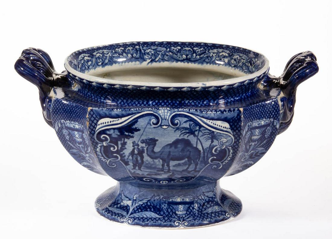 STAFFORDSHIRE QUADRUPEDS TRANSFER-PRINTED CERAMIC SOUP: STAFFORDSHIRE QUADRUPEDS TRANSFER-PRINTED CERAMIC SOUP TUREEN BASE, ovoid lobed form, featuring dark blue transfer of an Arabian Camel and handler with lattice and scrolled foliate border decoration. 