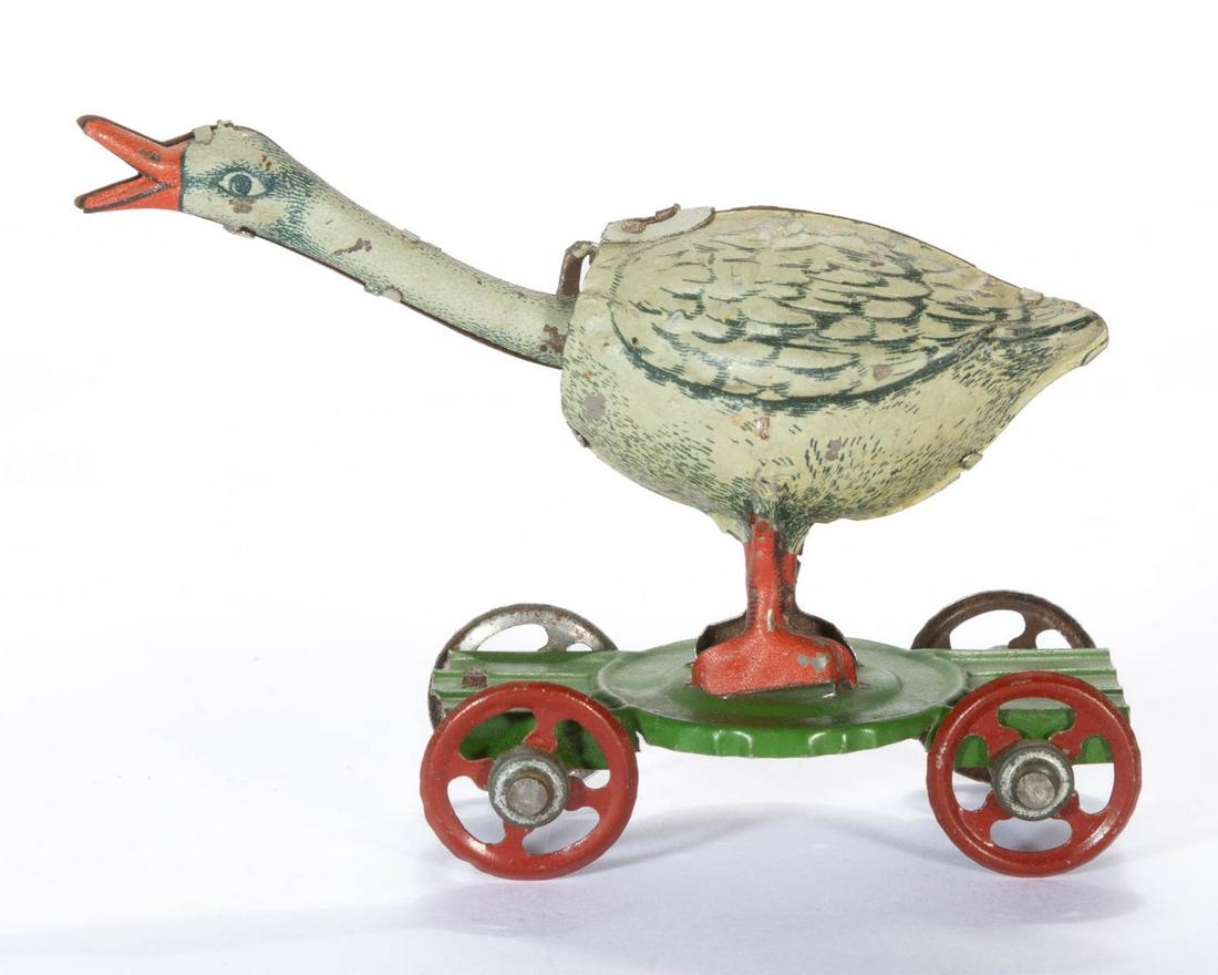 DISTLER GERMAN LITHOGRAPHED TIN NODDING GOOSE PENNY TOY: DISTLER GERMAN LITHOGRAPHED TIN NODDING GOOSE PENNY TOY, featuring a white goose with head out-stretched and honking, mounted on a base with wheels. Unmarked, attributed to Distler. Early 20th century