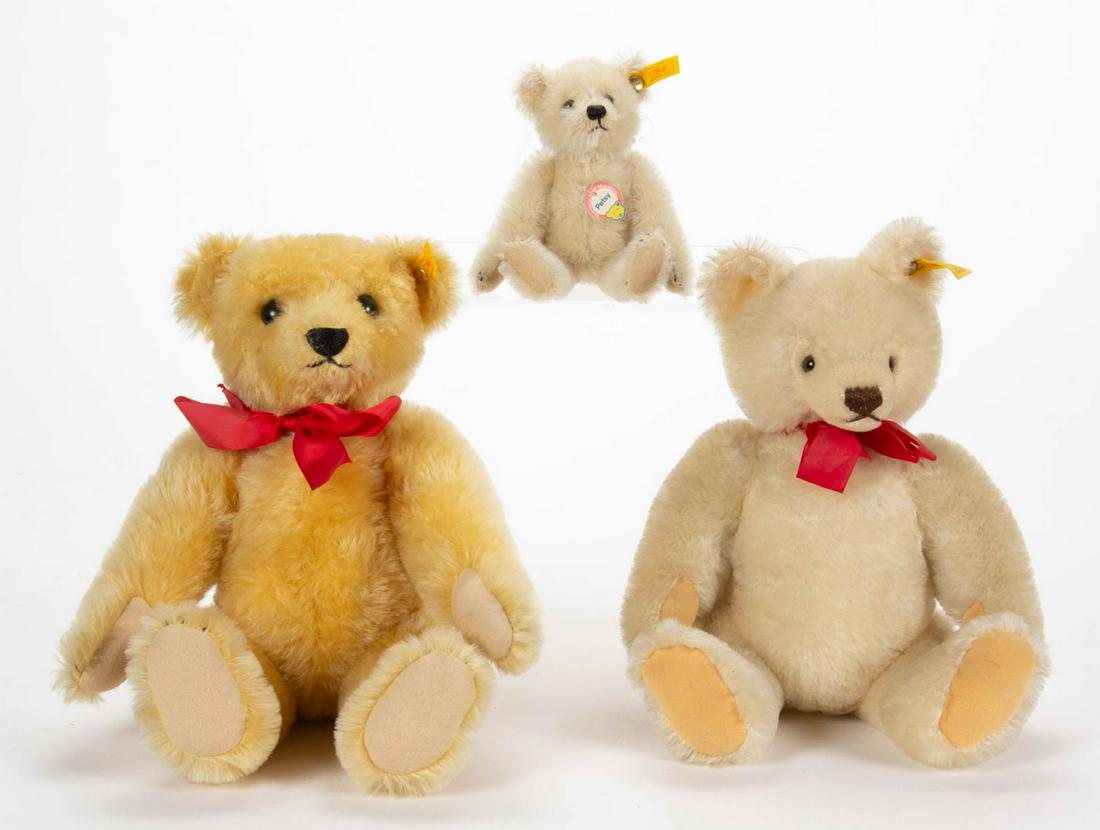 GERMAN STEIFF STUFFED TEDDY BEARS, LOT OF THREE: GERMAN STEIFF STUFFED TEDDY BEARS, LOT OF THREE, blonde mohair, each with brown eyes and black floss noses, swivel heads, jointed arms and legs, felt pads, and two large examples with a red bow, yello
