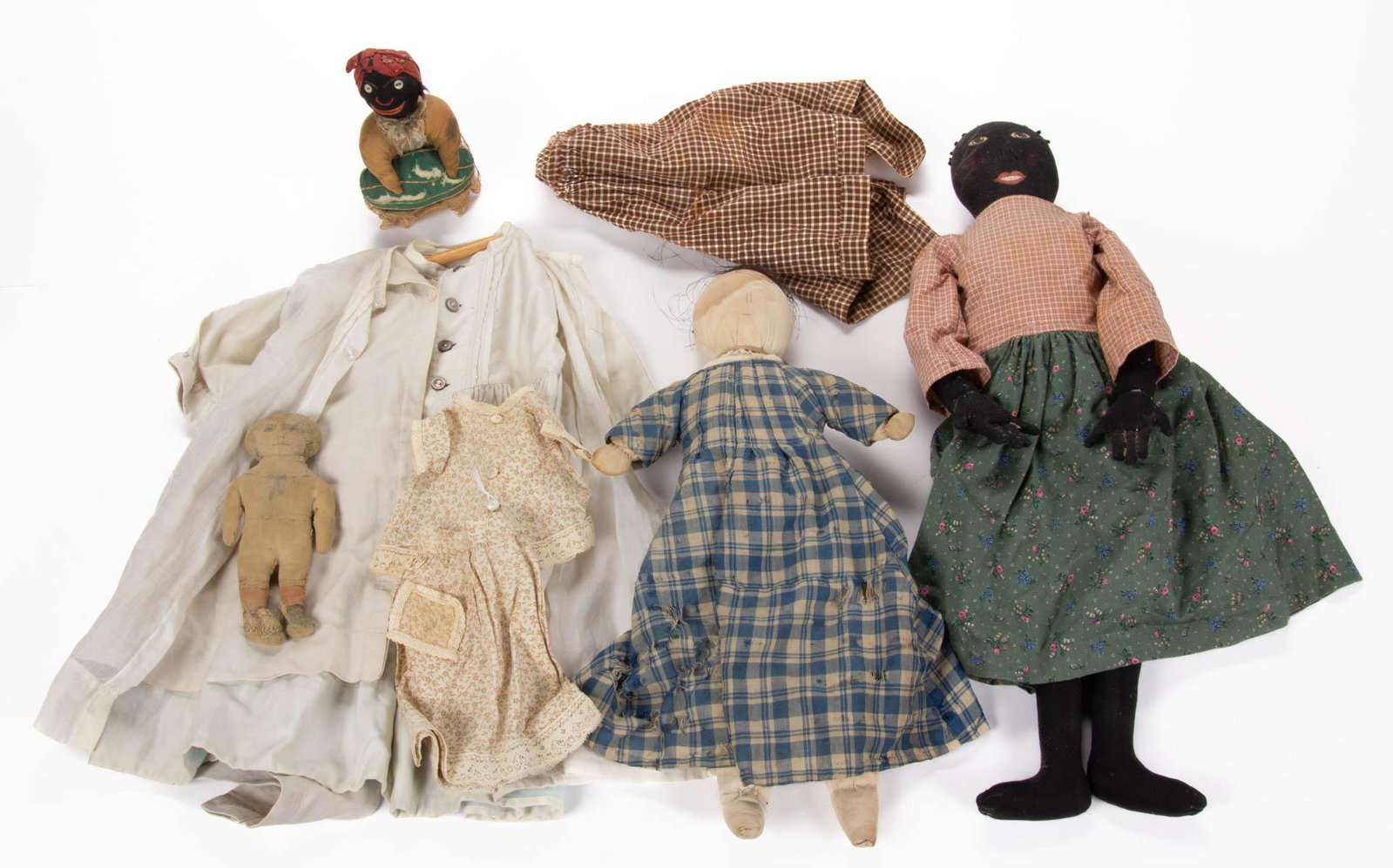 FOLK ART BLACK AMERICANA DOLLS AND OTHER ARTICLES, LOT: FOLK ART BLACK AMERICANA DOLLS AND OTHER ARTICLES, LOT OF EIGHT, including pin cushion example holding a watermelon with sewn on mother of pearl buttons for eyes, example with painted face. 20th centu