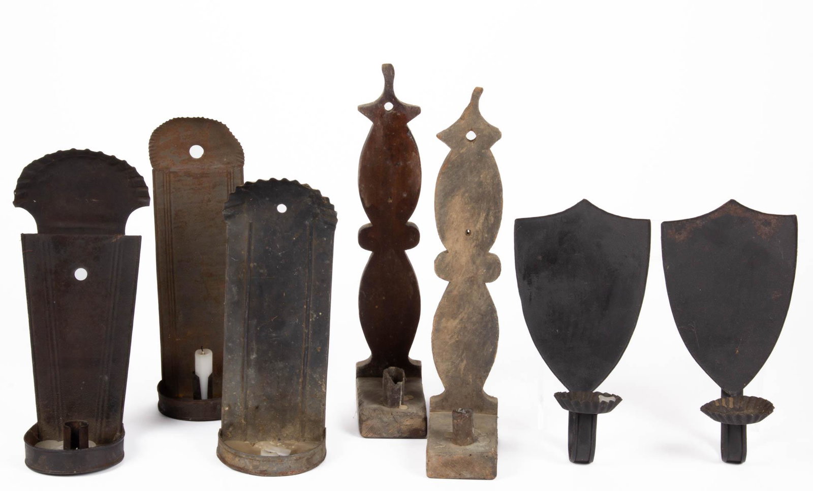ASSORTED SHEET-IRON AND WOODEN CANDLE WALL SCONCES, LOT: ASSORTED SHEET-IRON AND WOODEN CANDLE WALL SCONCES, LOT OF SEVEN, comprising five sheet-iron examples, including a pair in a shield form, remaining with crimped arch tops, beaded panels and hanging ho