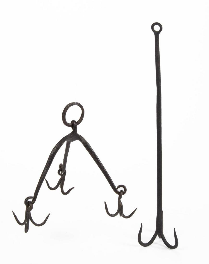 ASSORTED WROUGHT-IRON HEARTH GAME / MEAT HOOKS, LOT OF: ASSORTED WROUGHT-IRON HEARTH GAME / MEAT HOOKS, LOT OF TWO, comprising an example with three arms, each fitted with a tripartite hook, ring extension; and a central shaft example terminating in a trip