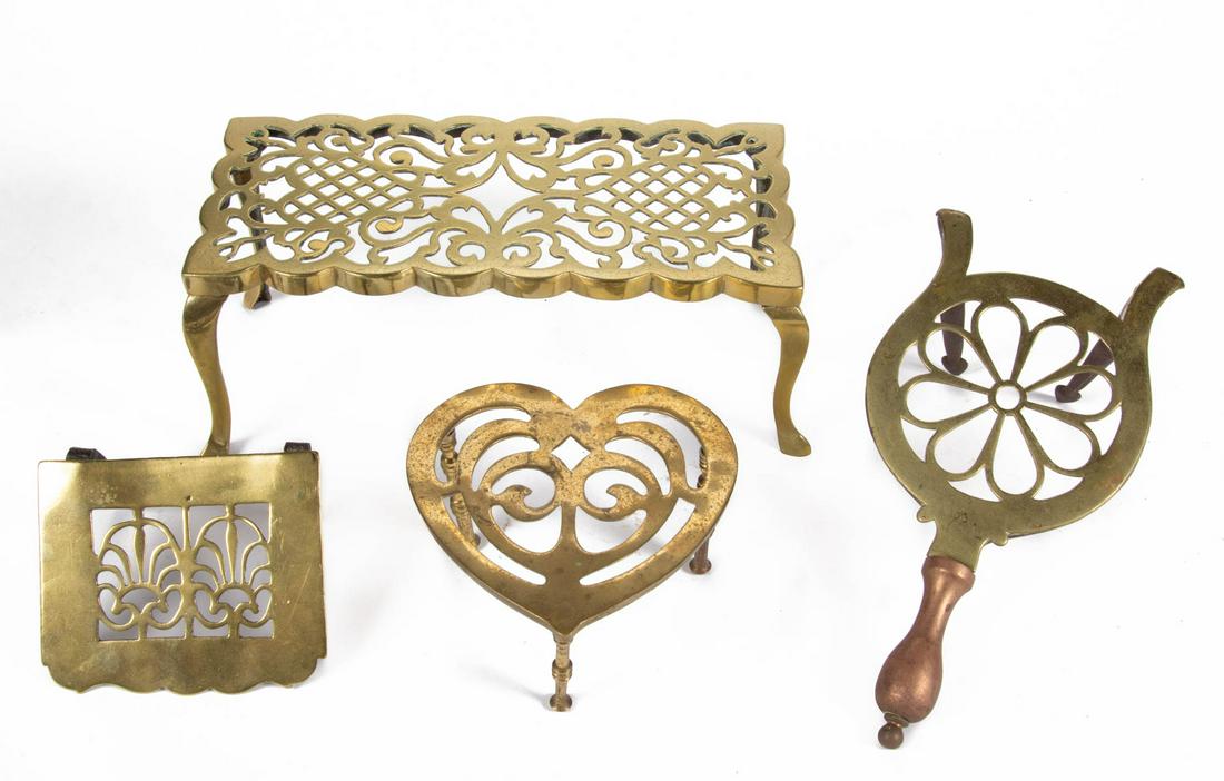 ASSORTED ENGLISH CAST BRASS AND WROUGHT-IRON HEARTH AND: ASSORTED ENGLISH CAST BRASS AND WROUGHT-IRON HEARTH AND KITCHEN TRIVETS, LOT OF THREE, various forms with stylized open-work patterns, comprising a rectangular-form raised on four scroll legs; an exam