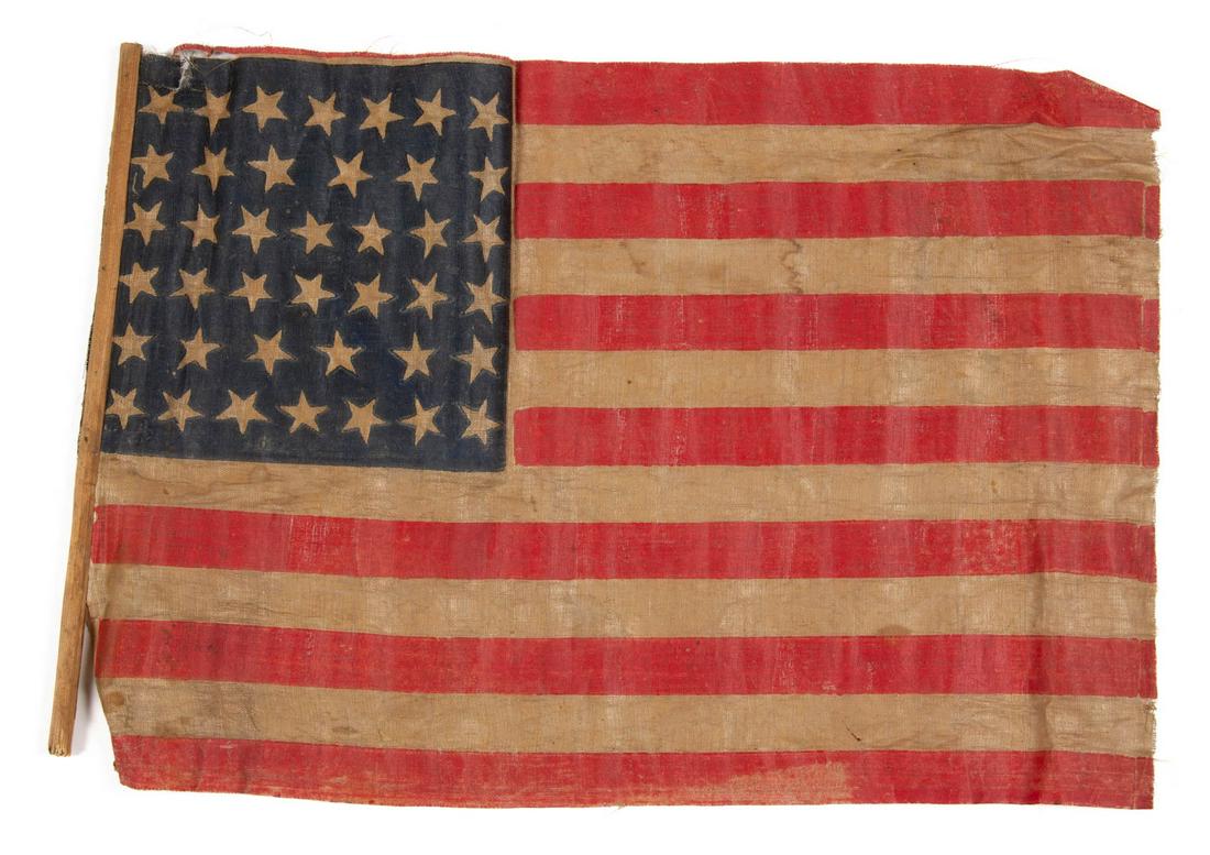 RARE 40-STAR UNOFFICIAL AMERICAN NATIONAL SOUTH DAKOTA: RARE 40-STAR UNOFFICIAL AMERICAN NATIONAL SOUTH DAKOTA STATEHOOD PARADE FLAG, printed glazed cotton muslin, the blue canton featuring six rows of five-pointed stars arranged in a "dancing" pattern of 