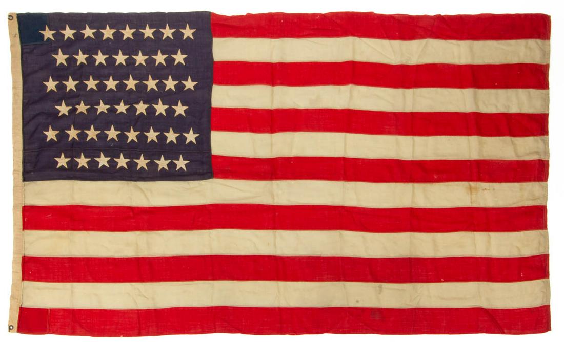 45-STAR AMERICAN NATIONAL FLAG: 45-STAR AMERICAN NATIONAL FLAG, machine-sewn, canton featuring double-appliqued cotton linen stars on a dark pieced blue wool bunting ground, fly with 13 red-and-white wool bunting stripes, applied ca