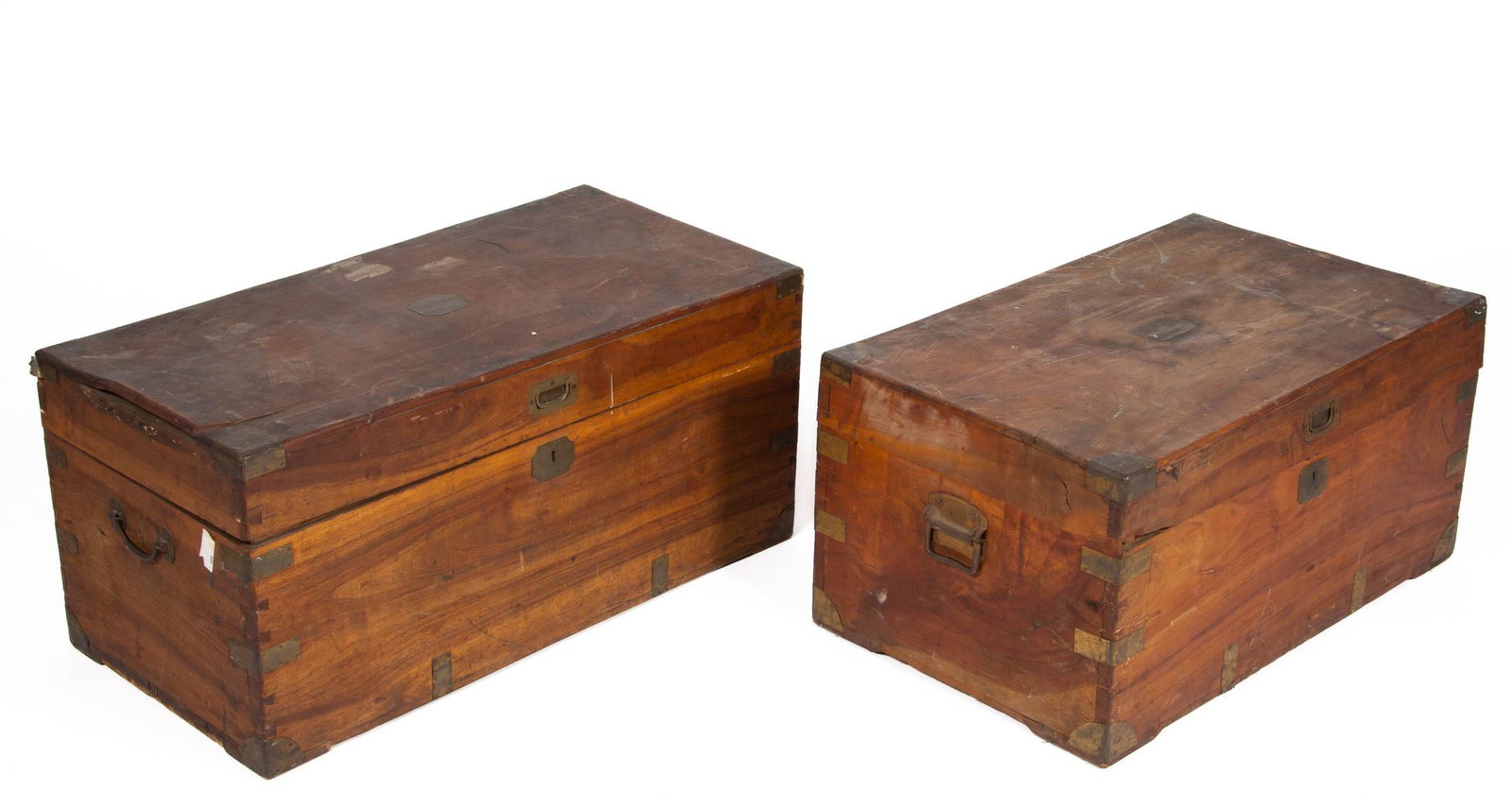 BRITISH BRASS-BOUND TEAK CAMPAIGN CHESTS / TRUNKS, LOT: BRITISH BRASS-BOUND TEAK CAMPAIGN CHESTS / TRUNKS, LOT OF TWO, including one with applied plaque engraved "Irwin". Each retains an old surface with mild color. Fourth quarter 19th century. 14 1/4" H, 