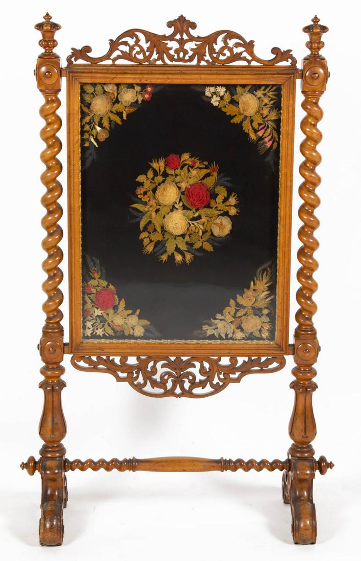 VICTORIAN EXOTIC WOOD FIRE SCREEN: VICTORIAN EXOTIC WOOD FIRE SCREEN, featuring central needlework panel with floral designs, flanked by barley twist columns, raised on scrolled feet, retains traces of original backing. Retains an old 