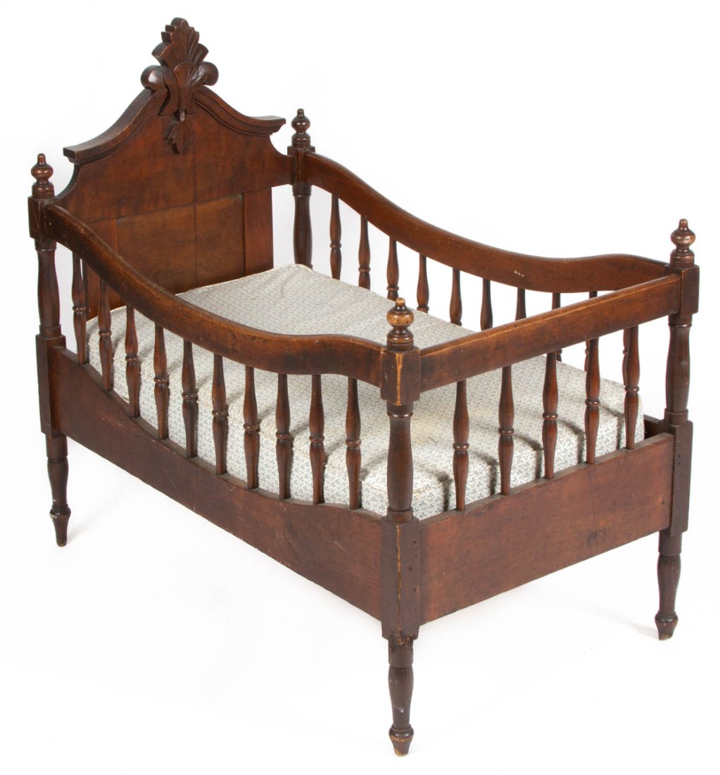 AMERICAN VICTORIAN WALNUT CRIB / BABY BED: AMERICAN VICTORIAN WALNUT CRIB / BABY BED, raised on turned legs terminating in a spade foot, retains likely original surface with warm color. Fourth quarter 19th century. 36 1/4" HOA, 23" W, 39" L. P