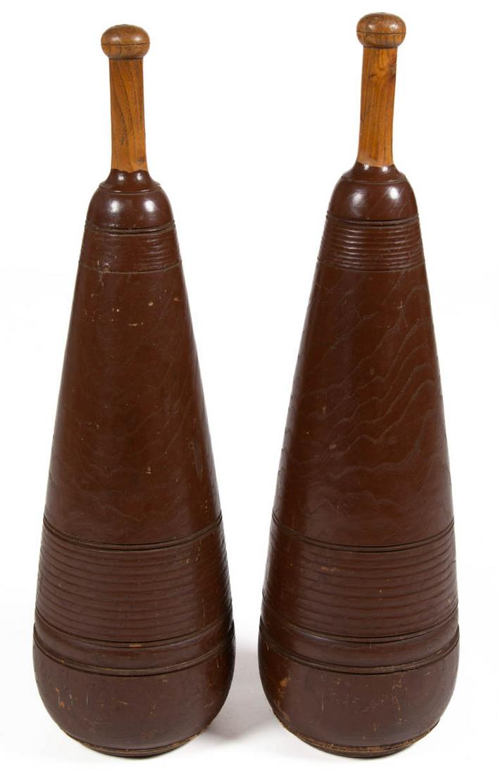 PAIR OF FOLK ART TURNED AND PAINTED WOODEN INDIAN /: PAIR OF FOLK ART TURNED AND PAINTED WOODEN INDIAN / EXERCISE CLUBS, cone-form with baseball bat-style handles, each with an old brown-painted surface. Circa 1940. 29" H.Provenance: From a Washington,
