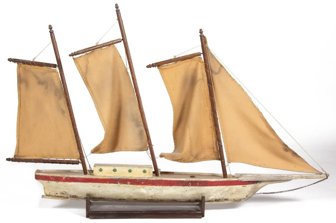 AMERICAN FOLK ART PAINTED POND BOAT / SHIP MODEL: AMERICAN FOLK ART PAINTED POND BOAT / SHIP MODEL, featuring canvas masts, and applied ship's windows, situated on a custom display. Retains an old red and white painted surface. 20th century. 45 1/2"