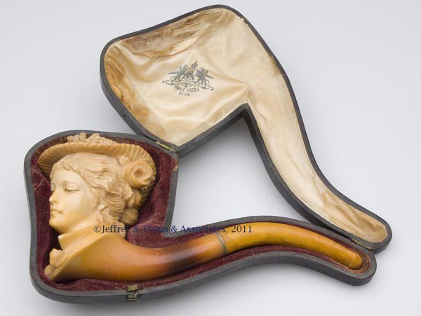 CARVED MEERSCHAUM PIPE IN CASE: CARVED MEERSCHAUM PIPE IN CASE, depicting a female bust wearing a fancy hat, original fitted case marked for "FRANZ HIESS / WIEN." Late 19th/early 20th century. 6" L. Provenance: Property of a New Jer