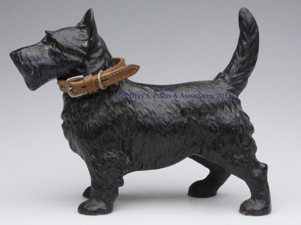 SCOTTIE CAST-IRON DOORSTOP: SCOTTIE CAST-IRON DOORSTOP, hollow full figure, original paint. Hubley #305. First half 20th century. 8 3/4" H, 11" W. Provenance: From a New York estate.