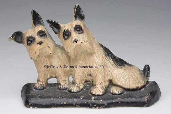 TWIN SITTING SCOTTIES CAST-IRON DOORSTOP: TWIN SITTING SCOTTIES CAST-IRON DOORSTOP, half figure, original paint. First half 20th century. 6" H, 8 3/4" W. Provenance: From a New Jersey estate collection.