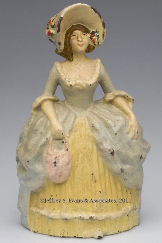 WOMAN WITH LARGE HAT CAST-IRON DOORSTOP: WOMAN WITH LARGE HAT CAST-IRON DOORSTOP, half figure, original paint. First half 20th century. 10 1/4" H, 6" W. Provenance: From a New York estate.