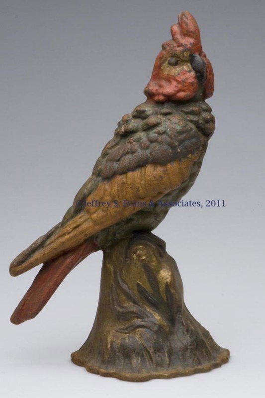 COCKATOO ON STUMP CAST-IRON DOORSTOP: COCKATOO ON STUMP CAST-IRON DOORSTOP, variation base with foliage, half figure, original paint. Albany Foundry. First half 20th century. 12" H, 7 1/2" W. Provenance: From a New York estate.