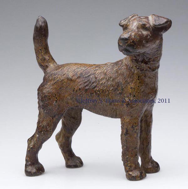 FOX TERRIER FACING RIGHT CAST-IRON DOORSTOP: FOX TERRIER FACING RIGHT CAST-IRON DOORSTOP, hollow full figure, original paint with old varnish. Hubley or National Foundry. First half 20th century. 8" H, 8" L. Provenance: From a New York estate.