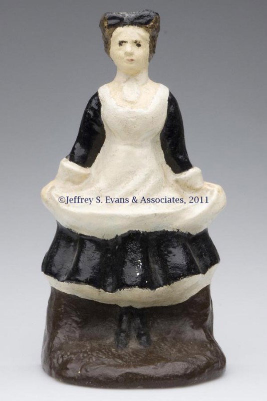 MILK MAID IN APRON CAST-IRON DOORSTOP: MILK MAID IN APRON CAST-IRON DOORSTOP, solid half figure, probably old repaint. First half 20th century. 9" H, 4 3/4" W. Provenance: From a New York estate.