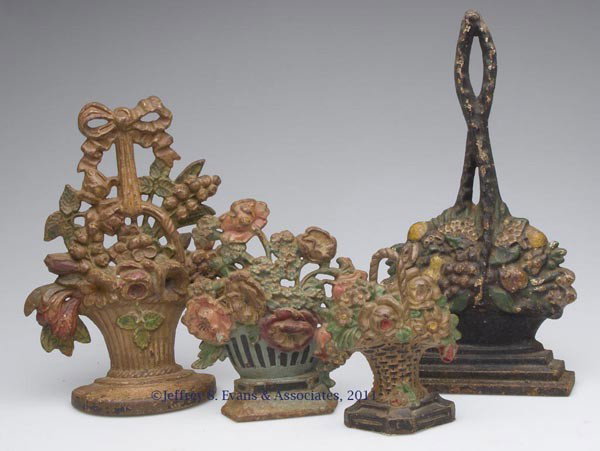 ASSORTED FLOWER BASKET FIGURAL CAST-IRON DOORSTOPS: ASSORTED FLOWER BASKET FIGURAL CAST-IRON DOORSTOPS, LOT OF FOUR, each half figure with original paint. First half 20th century. 5 3/4" to 12 7/8" H. Provenance: From a New York estate.