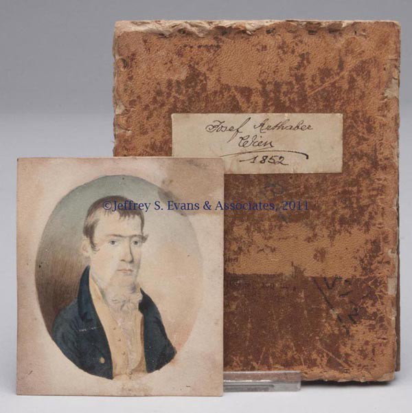 UNIDENTIFIED MINIATURE PORTRAIT OF A GENTLEMAN: UNIDENTIFIED MINIATURE PORTRAIT OF A GENTLEMAN, watercolor on paper, the subject dressed in a blue coat with yellow vest. Not framed, with a leather-covered board labeled Josef Arthaber Crim 1852. Mid