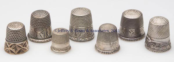 STERN BROS. AND GOLDSMITH, STERN & CO. STERLING SI: STERN BROS. AND GOLDSMITH, STERN & CO. STERLING SILVER THIMBLES, LOT OF SEVEN, consisting of three scenic landscape examples; a Bow, Ribbons, and Lilies-of-the-Valley; a grape band; a chased and engra