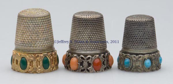 GERMAN SILVER WITH STONE THIMBLES, LOT OF THREE: GERMAN SILVER WITH STONE THIMBLES, LOT OF THREE, each with an applied scroll-work frieze band containing six set stones, consisting of coral example with various shades of stones and a scallop rim; a 